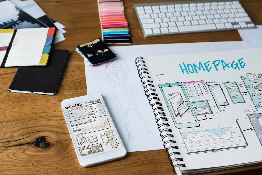 Блокнот, телефон и зарисовки на столе