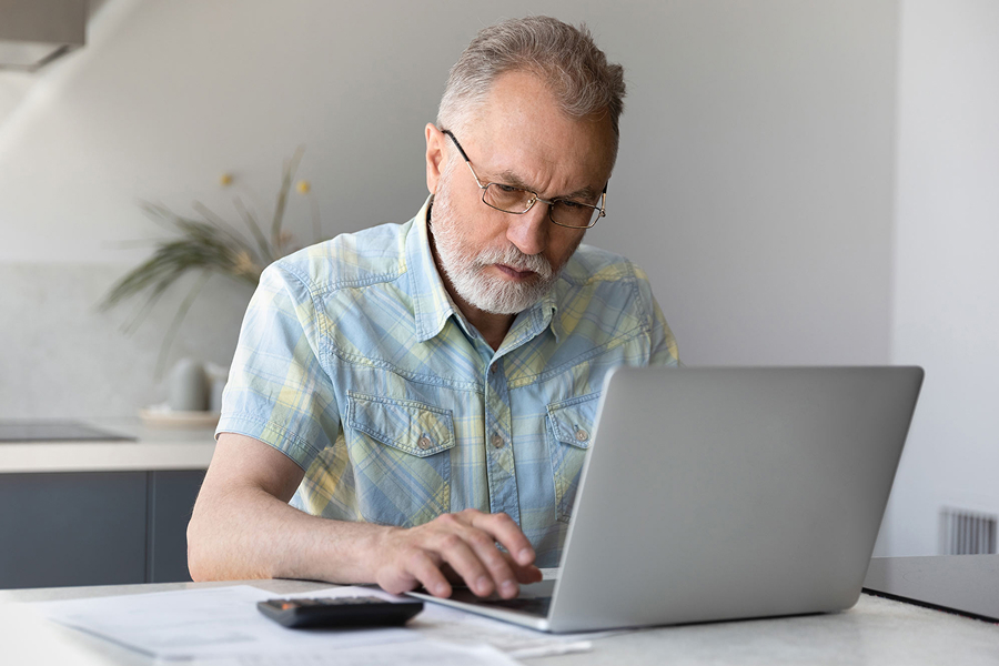 Мужчина в очках смотрит в ноутбук